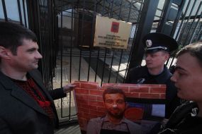 A man holds a poster featuring  Ivan Urganta