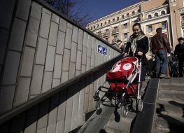 Женщина свозит коляску в подземный переход