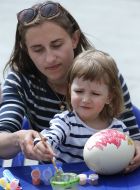 A girl with her mother decorate Easter Egg