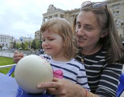 A girl with her mother decorate Easter Egg