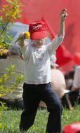 Girl in a cap with communist symbols weaves a wreath of dandelions