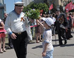 The boy gives flowers to a veteran of the Second World War
