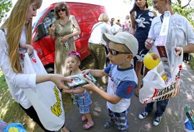 A girl presents gifts to children
