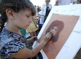 Girl paints a portrait of mother