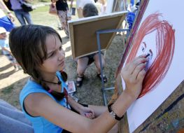 Girl paints a portrait of mother