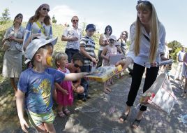 A girl presents gifts to children