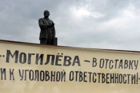 Плакат на фоне памятника Ленину