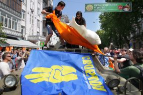 The participants of the mass meeting remove the dummy of carrot from the armoured troop-carrier off 