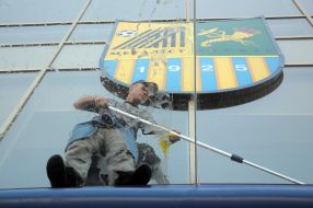 Worker cleans glass roof stadium "Metalist"