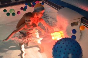 Девочка купается в бассейне