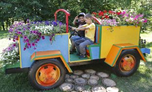 Children sit on the car decorated with flowers