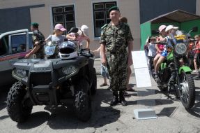 Children sit on the border vehicles