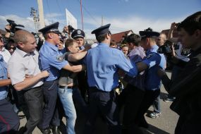 Police officers detain protesters