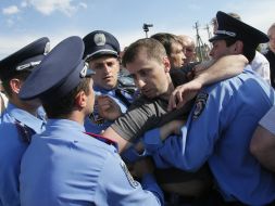 Police officers detain protesters