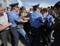 Police officers detain protesters