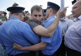 Police officers detain protesters