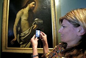 A woman photographs the "Jesus Christ" picture 