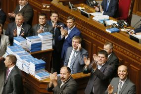 Депутаты складывают экземпляры послания Президента на трибуне