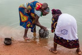 Жінки миють посуд у річці