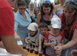 Кухар роздає дітям розлите в стаканчики варення 