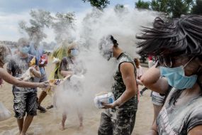 Young people sprinkle each other with flour