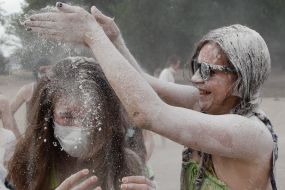 Young people sprinkle each other with flour
