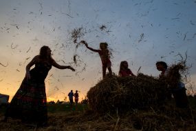 Girls jumping through a haystack