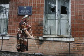 A woman cleans territory of police department