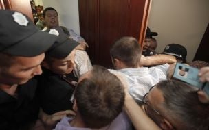 Participants of the protest try to get into the building KSCA