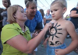Woman paints boy the mud