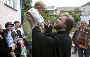 Олег Мельничук тримає на руках дитину