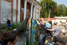 Участники акции протеста сносят забор