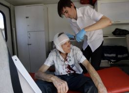 A doctor gives first medical help to the participant of action