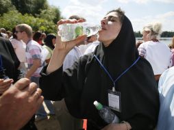 Жінка п'є освячену воду