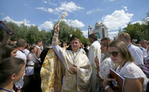 Священник окроплює освяченою водою вірян