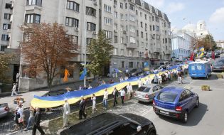 The participants of action hold the enormous flag of Ukraine