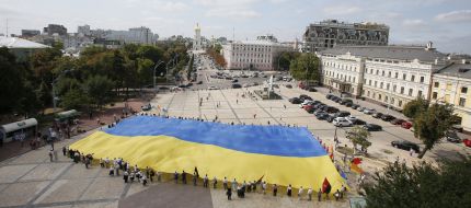 The participants of action hold the enormous flag of Ukraine
