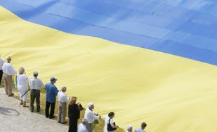 The participants of action hold the enormous flag of Ukraine