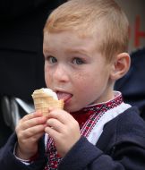 Мальчик ест мороженое