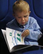 The boy looks at the book