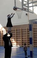 A girl throws a ball in basketball basket