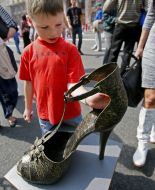 A boy examines a metal female slipper
