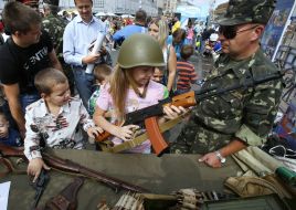 Girl in a helmet holding a machine gun