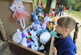 Девочка рассматривает мягкие игрушки