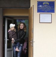 Женщина с ребенком выходят из детского сада