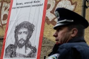 Militiaman stand near the poster