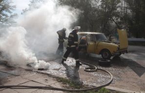 Firefighter extinguishes a burning car