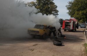 Firefighter extinguishes a burning car