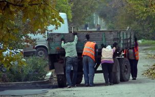Рабочие толкают автоприцеп