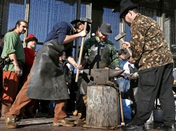 Blacksmiths forge a horseshoe
